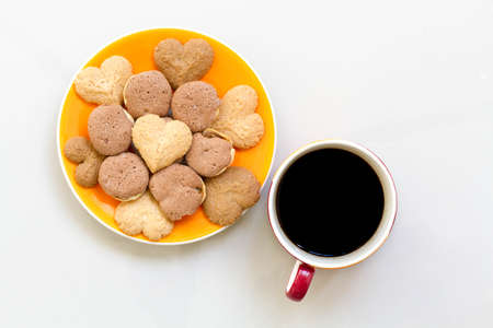 Chocolate cookies and butter cookies on white dish with black coffeeの写真素材