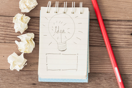 Idea alphabet on Little notebook with orange pencil on textured wooden background.の写真素材