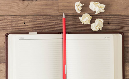 Note blank open book with orange pencil on textured wood backgroundの写真素材