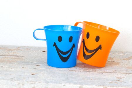 Smiling, Plastic glass of various color on wooden backgroundの写真素材