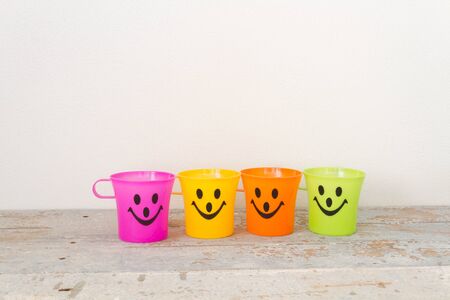 Smiling, Plastic glass of various color on wooden backgroundの写真素材