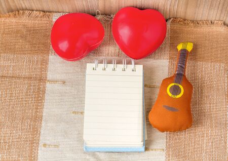 Double red heart with blank notebook on brown fabric, Nature lightの写真素材