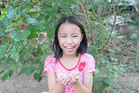 Close up happy adorable asian kids. Portrait of happy joyful smiling kids in the mulberry farm.の写真素材