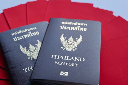 Together Thailand passport with pile red envelope isolated white background.の写真素材