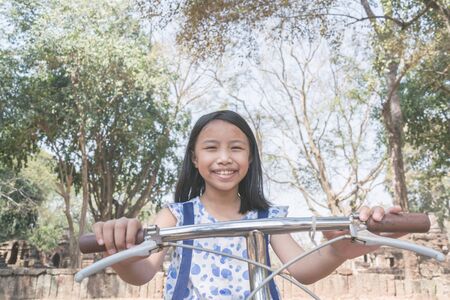 Asian cute girl riding bicycle in park.の写真素材