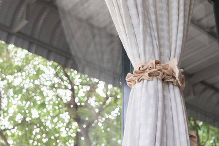 Vintage blinds are tied in front of the mirror.の写真素材