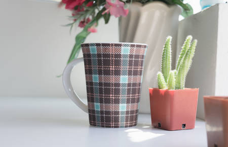 Mug of coffee on table in the coffee shop with flower.の写真素材