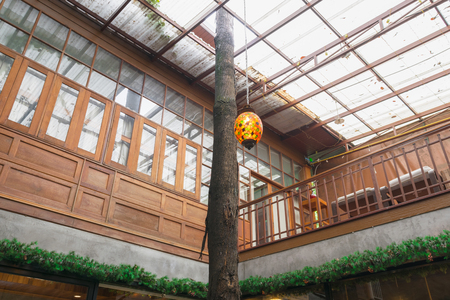 The old colorful lamp in a vintage style coffee shop, decorated with old tree in the middle of the house, concept of travel with delicious life in coffee shop .の写真素材