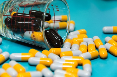 pills in glass over green background 