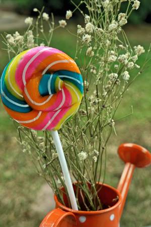 Colorful candies in vase on table on wooden backgroundの写真素材