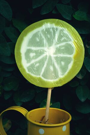 candies in vase on table on wooden backgroundの写真素材