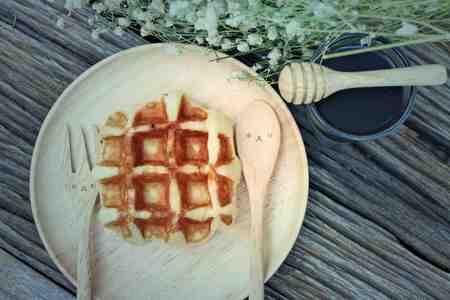 waffle and chocolate sauce on wooden platesの写真素材