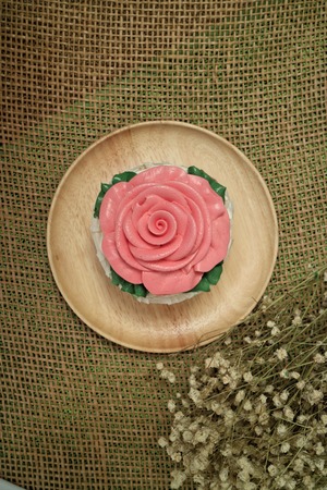 pink rose cupcake on wooden platesの写真素材