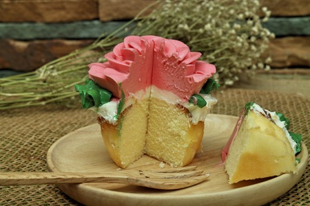 pink rose cupcake on wooden platesの写真素材