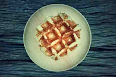 waffle and chocolate sauce on wooden platesの写真素材