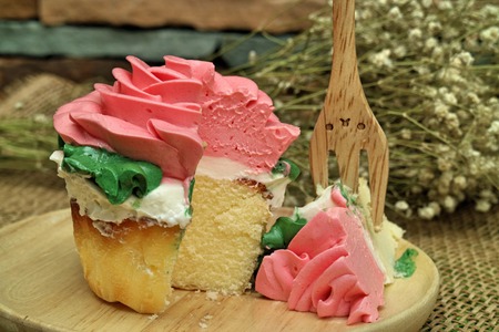 pink rose cupcake on wooden platesの写真素材