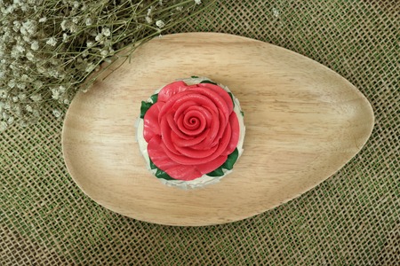 red rose cupcake on wooden platesの写真素材