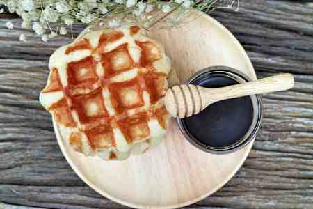 waffle and chocolate sauce on wooden platesの写真素材
