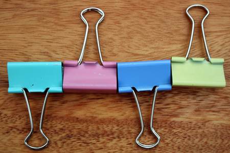 colorful binder clips  on wooden backgroundの写真素材