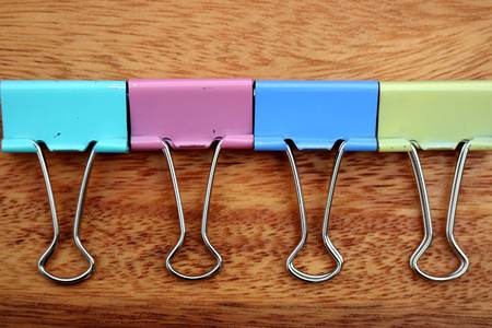 colorful binder clips  on wooden background