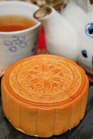 Traditional mooncakes and tea on table with teacup, Retro vintage style Chinese mid autumn festival foodsの写真素材