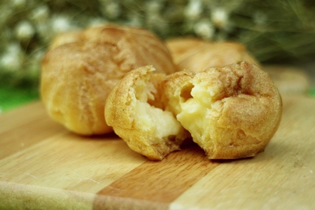 Eclair cream on a wooden platesの写真素材