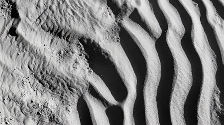 Close-up of rippling sand dunes, with fine patterns and shadows creating a hypnotic desert texture.の素材