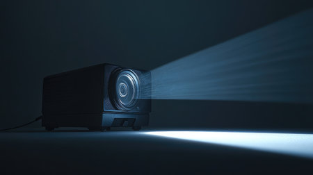 A modern projector emits a bright light beam in a dark setting, showcasing its functionality for presentations, movies, and visual displays in various environments.の素材