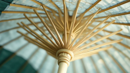 A stunning close-up image of a traditional paper umbrella viewed from below, highlighting its unique ribs and intricate structure set against a soft blue backdrop.の素材