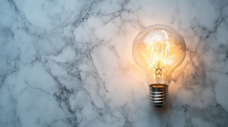 A stylish vintage light bulb radiates warmth, set against a textured marble backdrop. Perfect for design concepts and creative inspiration in artistic projects or interior decor.の素材
