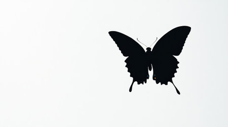 Butterfly in flight, captured as a black silhouette, standing out vividly against a stark white background for a minimalist scene.の素材