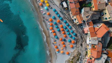 Aerial shot of Monterosso al Mare beach, Cinque Terre, with colorful umbrellas dotting the sandy shore and village homes in the background. No people included.の素材