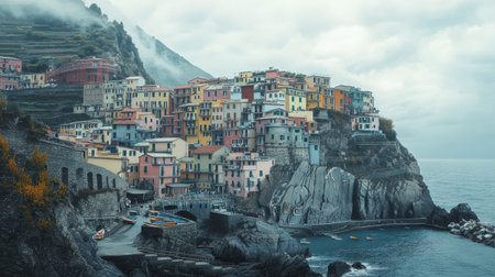 Close-up of the iconic pastel-colored homes of Manarola, Cinque Terre, nestled into the rugged cliffs with the sea in the background. No people included.の素材