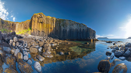 Panoramic shot of Fingal's Cave during a sunny day, with clear skies and calm waters providing a serene atmosphere. No people included.の素材