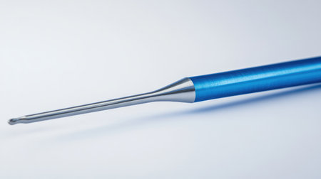 Close-up of dental scaler and curette against a sterile white backdrop.の素材