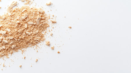 Closeup of wood shavings and powder forming a small pile on a pristine white background, showcasing natural tones and textures with copy spaceの素材