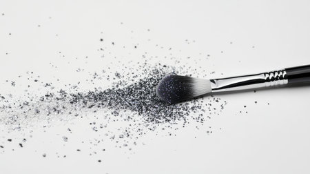 A professional makeup brush dipped in glittery eyeshadow, leaving a sparkling trail on the white surface.の素材