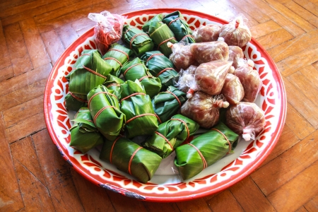 Sour pork : Thai northeastern style food which mixed pork rice garlic  and salt in banana leaf package and plastic packageの写真素材