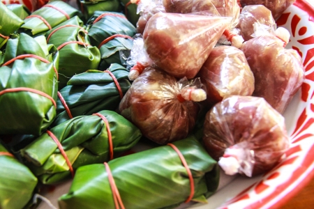 Sour pork : Thai northeastern style food which mixed pork rice garlic  and salt in banana leaf package and plastic packageの写真素材