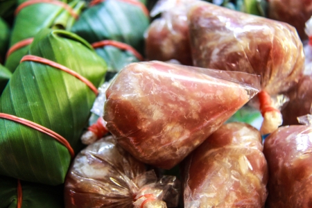 Sour pork : Thai northeastern style food which mixed pork rice garlic  and salt in banana leaf package and plastic packageの写真素材