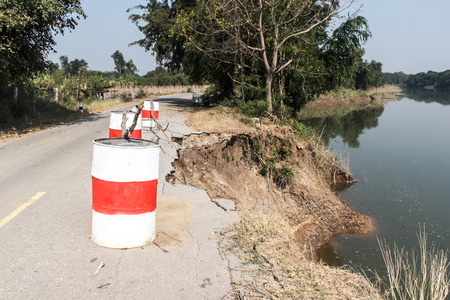 soil under the asphalt road collapsed from water erosionの写真素材