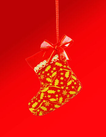 Christmas sock hanging over red background.の写真素材