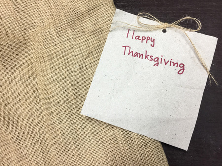 Happy thanksgiving text on brown paper and sackcloth on wood table.の写真素材