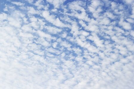 Fluffy small clouds on blue sky background.の写真素材