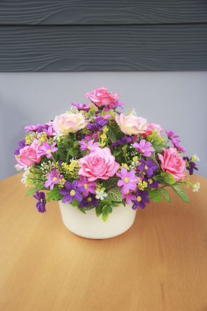 Pink rose bouquet on wood table and gray wall background with copy-space, soft focus.の写真素材