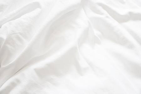 Close up of white bedding sheets and copy space.