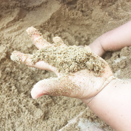 Sand in hand child age 2 years.の写真素材