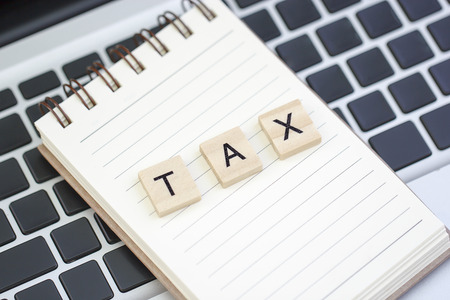 Text TAX made from wood on notebook and on laptopの写真素材