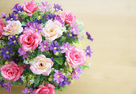 Pink rose bouquet on wood table and gray wall background with copy-space, soft focus.の写真素材