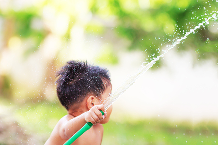 Boy playing water in the garden.の写真素材